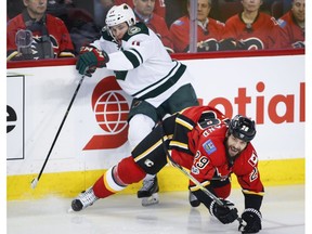 Minnesota Wild left wing Zach Parise is checked by Calgary Flames defenceman Deryk Engelland in Calgary on Feb. 1, 2017. (File)