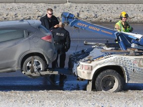 Emergency crews investigate the scene on northbound Deerfoot Tr near Peigan Tr SE in Calgary, Alta on Friday February 10, 2017. The tow truck driver was hit by a passing vehicle as he was loading a car and is in life threatening condition. Jim Wells//Postmedia