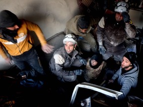 (FILES) This file photo taken on November 20, 2016 shows Syrian civil defence volunteers, known as the White Helmets, helping a victim following a reported airstrikes on Aleppo's rebel-held district of al-Hamra. Rescue workers from Syria's White Helmets -- the subjects of an Oscar-nominated documentary -- said on February 18, 2017 they have received US visas to attend next week's prestigious Academy Awards ceremony.  /