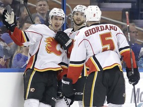 Calgary Flames center Mikael Backlund, (11) of Sweden, celebrates with teammates including defenseman Mark Giordano (5) after scoring against the Tampa Bay Lightning during the second period of an NHL hockey game Thursday, Feb. 23, 2017, in Tampa, Fla. (AP Photo/Chris O'Meara) ORG XMIT: TPA107