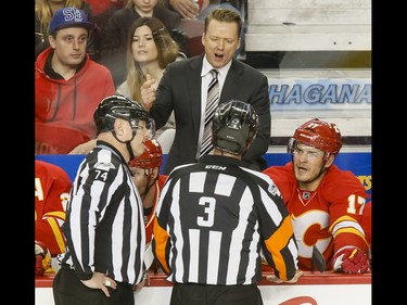 Calgary Flames coach Glen Gulutzan talks to referee Mike Leggo near linesman Lonnie Cameron after a first-period Flames penalty during NHL action against the Philadelphia Flyers in Calgary, Alta., on Wednesday, Feb. 15, 2017. Lyle Aspinall/Postmedia Network