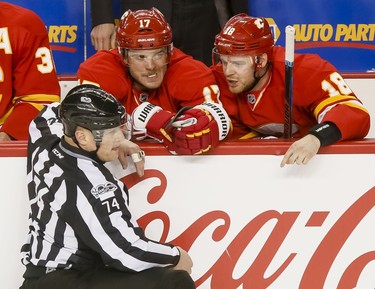 Matt Stajan (R) and Lance Bouma of the Calgary Flames offer their opinion to linesman Lonnie Cameron after a first-period penalty during NHL action against the Philadelphia Flyers in Calgary, Alta., on Wednesday, Feb. 15, 2017. Lyle Aspinall/Postmedia Network