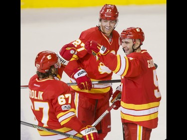 Mark Giordano of the Calgary Flames celebrates his last-minute insurance goal with teammtes Michael Frolik and Dougie Hamilton after beating the Philadelphia Flyers 3-1 in NHL action in Calgary, Alta., on Wednesday, Feb. 15, 2017. Lyle Aspinall/Postmedia Network