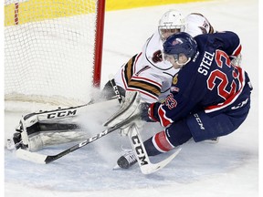 Calgary Hitmen goalie Trevor Martin, left, stops a shot on net from Regina Pats Sam Steel in WHL action at the Scotiabank Saddledome in Calgary, Alberta, on Wednesday, February 8, 2017. Leah Hennel/Postmedia