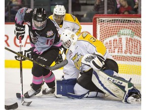 Tristen Nielsen of the Calgary Hitmen is stopped by of the Brandon Wheat Kings goalie Travis Child near Caiden Daley during the first-ever BE BRAVE Anti-Bullying Game, a regular-season WHL tilt between the Calgary Hitmen and Brandon Wheat Kings, in Calgary, Alta., on Wednesday, Feb. 22, 2017.