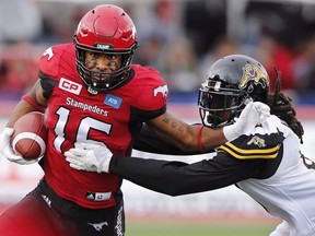 Hamilton Tiger-Cats linebacker Rico Murray, right, tried to tackle Calgary Stampeders slotback Marquay McDaniel during second half CFL football action in Calgary on Sunday, Aug. 28, 2016.