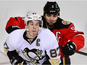 Pittsburgh Penguins Sidney Crosby takes cross check from Mark Giordano of the Calgary Flames during a previous meeting in Calgary. (Al Charest)