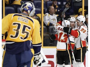 Calgary Flames left wing Micheal Ferland (79) is congratulated by Johnny Gaudreau (13) and Sean Monahan (23) after Ferland scored a goal against Nashville Predators goalie Pekka Rinne (35), of Finland, during the first period of an NHL hockey game Tuesday, Feb. 21, 2017, in Nashville, Tenn.