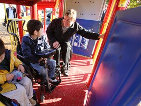 Rick Hansen joins some friends at an accessible playground. Calgary's Variety Park was recently picked to be a Barrier Buster project to improve accessibility for people with disabilities.