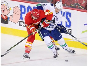 The Calgary Flames' Garnet Hathaway and the Vancouver Canucks' Luca Sbisa battle for control during NHL action at the Scotiabank Saddledome in Calgary on Saturday January 7, 2017. The two team play again on Saturday.
