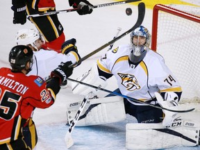The Calgary Flames' Freddie Hamilton reaches for a flying puck in front of Nashville Predators goaltender Juuse Saros at the Scotiabank Saddledome on Jan. 19, 2017. (Gavin Young)