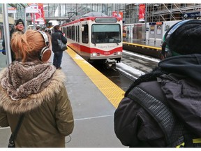 CTrain commuters wear headphones while they wait for their trains at the City Hall station on Thursday February 23, 2017.