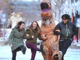 Daniel Petke is dressed in an inflatable dinosaur suit and dances with Amanda Baird Gray, Brenda Rooney and Steve Gray on Stephen Avenue Walk near Macleod Tr SW in downtown Calgary, Alta  on Saturday February 11, 2017. Petke's wife has a rare disease called chiari malformation and the family is struggling to pay medical bills. He has taken to busking (legally) in the suit to help raise extra funds. Jim Wells/Postmedia