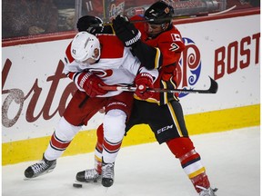 Carolina Hurricanes' Joakim Nordstrom, left, from Sweden, battles for the puck with Calgary Flames' T.J. Brodie during second period NHL hockey action in Calgary, Thursday, Oct. 20, 2016. The two teams play again Sunday.