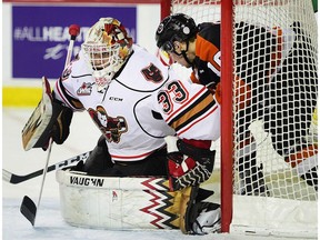 FILE PHOTO: Tigers forward Max Gerlach collects himself from inside the Hitmen net while Kyle Dumba maintains focus on the play as the Calgary Hitmen took on the Medicine Hat Tigers at the Scotiabank Saddledome in Calgary, Alta., on February 10, 2017. The Tigers won 7-2.