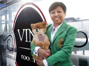 Phoebe Fung, proprietor of Vin Room West in Calgary, is all smiles with her Pomeranian named Dom.