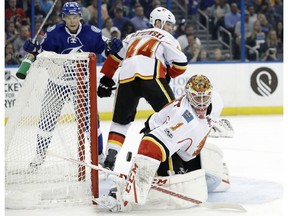 Calgary Flames goalie Brian Elliott makes a blocker save as Tampa Bay Lightning center Vladislav Namestnikov and defenceman Matt Bartkowski look for a rebound Thursday, Feb. 23, 2017, in Tampa, FL. (Chris O'Meara/AP Photo)