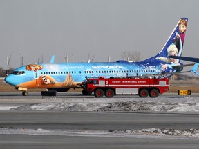 A WestJet 737 is checked over by a fire crew after landing safely in Calgary after reports of smoke in the cockpit on Thursday Feb. 2, 2017.