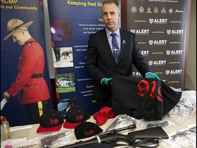 ALERT CEO and Acting Supt. Chad Coles with some of the estimated $25,000 of drugs, gang support clothing and guns seized in Red Deer, Alta., on Tuesday March 14, 2017. Leah Hennel/Postmedia