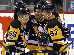 Pittsburgh Penguins&#039; Sidney Crosby (87) celebrates with Conor Sheary, center, and Jake Guentzel (59) after getting a hat-trick with his third goal of the game in the third period of an NHL hockey game against the Florida Panthers in Pittsburgh, Sunday, March 19, 2017. Pittsburgh won 4-0. (AP Photo/Gene J. Puskar)