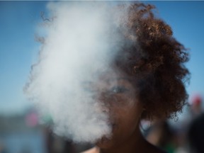 A woman who didn't want to be identified by name exhales after taking a hit from a bong during the annual 4/20 cannabis culture celebration at Sunset Beach in Vancouver, B.C., on Wednesday April 20, 2016. THE CANADIAN PRESS/Darryl Dyck ORG XMIT: VCRD104