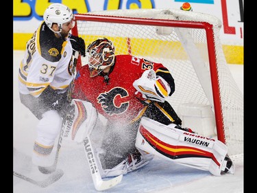 Boston Bruins  Patrice Bergeron collides with Chad Johnson of the Calgary Flames during NHL hockey in Calgary, Alta., on Wednesday, March 15, 2017. AL CHAREST/POSTMEDIA