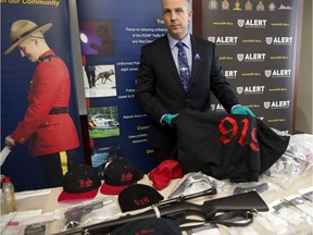 ALERT CEO and Acting Supt. Chad Coles with some of the estimated $25,000 of drugs, gang support clothing and guns seized in Red Deer, Alta., on Tuesday March 14, 2017. Leah Hennel/Postmedia