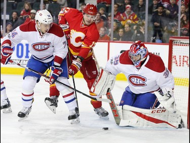 The Calgary Flames'  Lance Bouma and the Montreal Canadiens' Alexei Emelin looks to grab a loose puck in front of Montreal Canadiens goaltender Al Montoya during NHL action at the Scotiabank Saddledome on Thursday March 9, 2017.
GAVIN YOUNG/POSTMEDIA NETWORK