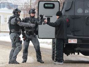 Calgary police tactical officers arrest a bank robbery suspect from a house on Danloe St. in Renfrew on Monday March 13, 2017.