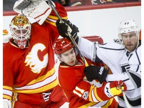 Calgary Flames goalie Brian Elliott shields himself near teammate Mikael Backlund and Jeff Carter of the Los Angeles Kings in Calgary on Sunday, March 19, 2017. (Lyle Aspinall)