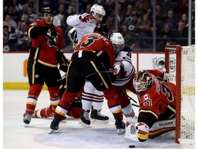 Calgary Flames goalie Chad Johnson stretches for the puck as the Winnipeg Jets scramble in front of the net on Jan. 9, 2017. (The Canadian Press)