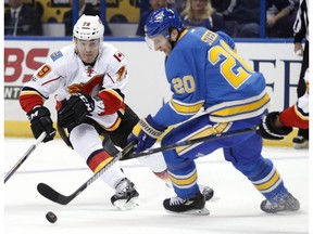 Calgary Flames forward Micheal Ferland and the St. Louis Blues' Alexander Steen, right, reach for a loose puck in St. Louis on Saturday, March 25, 2017. (Jeff Roberson/AP Photo)