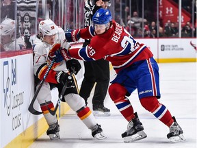Nathan Beaulieu #28 of the Montreal Canadiens pins Alex Chiasson #39 of the Calgary Flames against the boards during the NHL game at the Bell Centre on January 24, 2017 in Montreal, Quebec, Canada. The Montreal Canadiens defeated the Calgary Flames 5-1. The Flames host the Canadiens on Thursday.