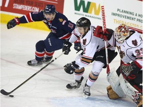 Hitmen defenceman Jake Bean scrambles out of his own end in front of goalie Kyle Dumba and Regina Pats' Jeff de Wit at the Scotiabank Saddledome on Tuesday, March 28, 2017. (Jim Wells)