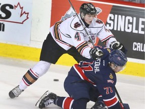 Htimen Micheal Zipp (4) hits Pats' Dawson Leedahl during WHL action between the Regina Pats and the Calgary Hitmen in Calgary, Alta at the Scotiabank Saddledome on Tuesday March 28, 2017.