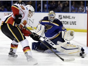 St. Louis Blues goalie Carter Hutton, right, makes a save on a shot by Calgary Flames' Matthew Tkachuk during the third period of an NHL hockey game Tuesday, Oct. 25, 2016, in St. Louis. The Flames won 4-1. The Flames play the Blues again on Saturday.
