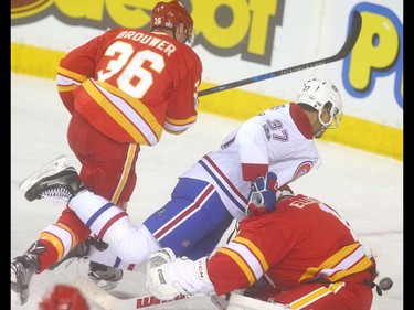 Canadiens Andreas Martinsen crashed into Flames goalie Brian Elliott in front of Calgary defender Troy Brouwer during NHL action between the Montreal Canadiens and the Calgary Flames in Calgary, Alta. on Thursday March 9, 2017 at the Scotiabank Saddledome. Jim Wells/Postmedia