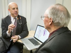 Dr. Michael Hill (L) speaks with stroke patient Ian MacNeill at the Health Sciences Centre at the Foothills Medical Centre in Calgary, Alta., on Monday, March 6, 2017. Alberta Health Services were touting a year-long quality improvement initiative that turned Alberta's 17 stroke treatment centres into some of the fastest in the world. Lyle Aspinall/Postmedia Network
