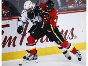 Los Angeles Kings' Dwight King, left, and Calgary Flames' Deryk Engelland vie for the puck during second period NHL hockey action in Calgary, Tuesday, Feb. 28, 2017. The Flames host the Kings again on Sunday.