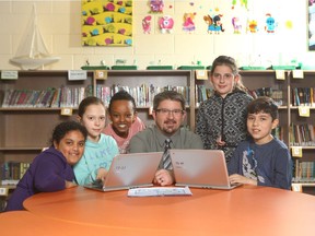 Joe Gillis (C) school principal at Father Doucet school in southwest Calgary, Alta poses with grade four students (L-R) Ashyka de Silva,Lulu Coyne, Naty Derbe, Claudia Surowiec and Sebastian Torro on Friday March 24, 2017.  Father Doucet is rising quickly in Fraser Institute rankings. Jim Wells/Postmedia