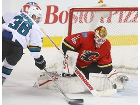 Flames goalie Brian Elliott stops Sharks Jannik Hansen in close during NHL action between the San Jose Sharks and the Calgary Flames in Calgary, Alta. on Friday March 31, 2017.