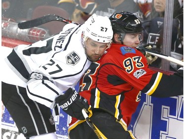 Kings Alec Martinez (L) traps Flames Sam Bennett along the glass in the corner during NHL action between the Los Angeles Kings and the Calgary Flames in Calgary, Alta. on Wednesday March 29, 2017. Jim Wells/Postmedia