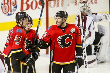 Sean Monahan, Mark Giordano and Troy Brouwer of the Calgary Flames celebrate Monahan's early first-period goal near Colorado Avalanche goalie Calvin Pickard during NHL action in Calgary, Alta., on Monday, March 27, 2017. Lyle Aspinall/Postmedia Network
