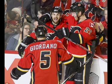 Michael Frolik, Dougie Hamilton and Mark Giordano of the Calgary Flames celebrate one of four first-period goals on the New York Islanders during NHL action in Calgary, Alta., on Sunday, March 5, 2017. The Flames were gunning for their seventh straight win. Lyle Aspinall/Postmedia Network