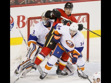Micheal Ferland of the Calgary Flames gets between Thomas Hickey of the New York Islanders and goalie Thomas Greiss during NHL action in Calgary, Alta., on Sunday, March 5, 2017. The Flames were gunning for their seventh straight win. Lyle Aspinall/Postmedia Network