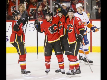 Lance Bouma, Matt Stajan, T.J. Brodie and Dougie Hamilton of the Calgary Flames celebrate the team's second of four first-period goal near Nikolay Kulemin of the New York Islanders during NHL action in Calgary, Alta., on Sunday, March 5, 2017. The Flames were gunning for their seventh straight win. Lyle Aspinall/Postmedia Network