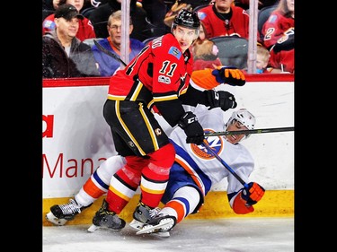 Calgary Flames Mikael Backlund collides with  Travis Hamonic of the New York Islanders during NHL hockey in Calgary, Alta., on Sunday, March 5, 2017. AL CHAREST/POSTMEDIA