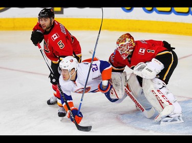 New York Islanders  Anders Lee battles against Mark Giordano and Brian Elliott of the Calgary Flames during NHL hockey in Calgary, Alta., on Sunday, March 5, 2017. AL CHAREST/POSTMEDIA