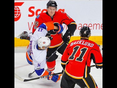 Calgary Flames Michael Stone knocks down Shane Prince of the New York Islanders during NHL hockey in Calgary, Alta., on Sunday, March 5, 2017. AL CHAREST/POSTMEDIA