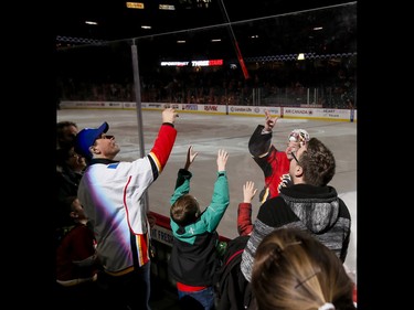 Calgary Flames goalie Brian Elliott, the game's third star, tosses his stick to fans after beating the New York Islanders in NHL action in Calgary, Alta., on Sunday, March 5, 2017. The Flames won 5-2, marking their seventh straight win. Lyle Aspinall/Postmedia Network